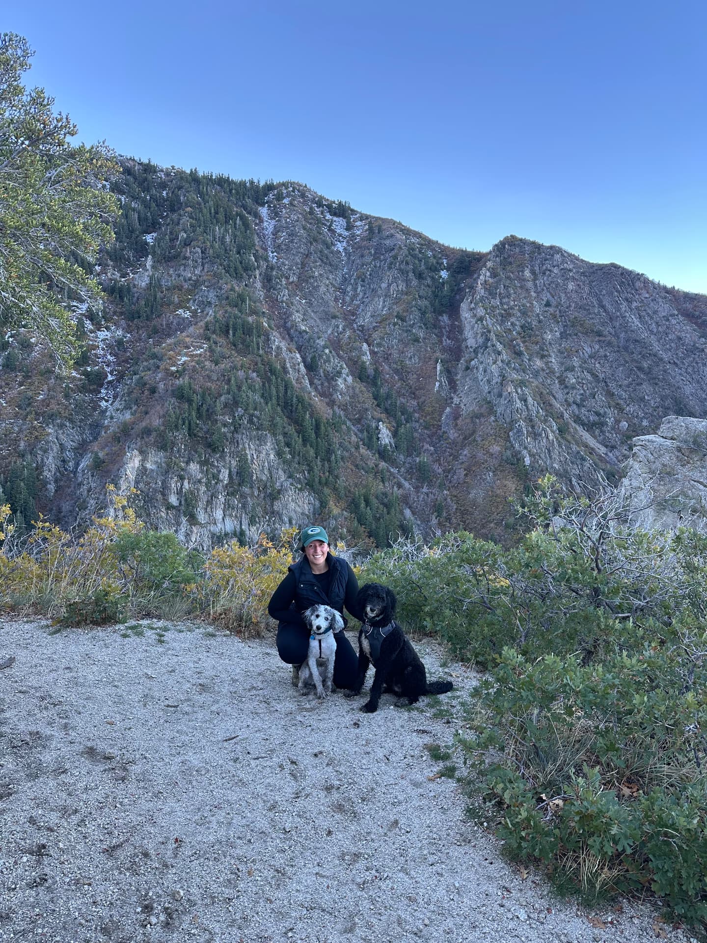 Melanie on a mountain trail with her dogs Denali and Goose
